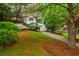 Traditional home with well-kept lawn and flower beds, features a white brick exterior, and attached garage at 648 Channing Nw Dr, Atlanta, GA 30318