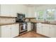 Well-lit kitchen with white cabinetry, stainless steel appliances, granite countertops, and tiled flooring at 648 Channing Nw Dr, Atlanta, GA 30318