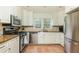 Updated kitchen featuring stainless steel appliances, white cabinets, and tile flooring at 648 Channing Nw Dr, Atlanta, GA 30318