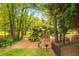 Well-equipped playground with climbing structures, slides, picnic table, and grill in a fenced area surrounded by mature trees at 648 Channing Nw Dr, Atlanta, GA 30318