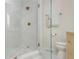Contemporary shower featuring white marble tile, bronze fixtures, and a glass door at 648 Channing Nw Dr, Atlanta, GA 30318