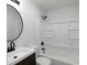 Updated bathroom features a shower-tub combo with a dark vanity, round mirror, and modern fixtures at 7965 Tower Dr, Douglasville, GA 30134