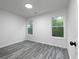 Bedroom featuring gray wood floors, white walls, and windows with natural light at 7965 Tower Dr, Douglasville, GA 30134
