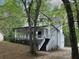 Two-story house with a charming porch and landscaped yard surrounded by tall, mature trees at 7965 Tower Dr, Douglasville, GA 30134