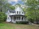 Stylish home with a turret, a welcoming porch and mature trees adding beauty to the property at 7965 Tower Dr, Douglasville, GA 30134