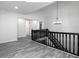 Hallway featuring gray wood floors, white walls, and black railing at 7965 Tower Dr, Douglasville, GA 30134