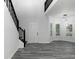 Bright living room showcasing a modern light fixture, gray flooring, and staircase with black railing at 7965 Tower Dr, Douglasville, GA 30134