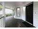 Inviting porch with wood flooring and a black front door leading to the home's entrance at 7965 Tower Dr, Douglasville, GA 30134