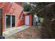 Backyard view with a concrete patio and a side door to a red townhome at 1797 Brookside Lay Cir, Norcross, GA 30093