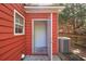 Exterior door on a red-sided home with an air conditioning unit and lush greenery at 1797 Brookside Lay Cir, Norcross, GA 30093