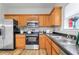 Close-up of kitchen featuring stainless steel appliances, wood cabinets and grey countertop at 1797 Brookside Lay Cir, Norcross, GA 30093