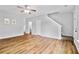 Bright living room with wood-look flooring, neutral walls, and staircase access to the upper level at 1797 Brookside Lay Cir, Norcross, GA 30093