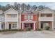 Charming townhouse featuring a red exterior, well-maintained landscaping, and convenient parking at 1797 Brookside Lay Cir, Norcross, GA 30093