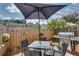 Backyard patio space with grill, table, chairs, umbrella, and wooden privacy fence at 2968 Greyhawk Ln, Cumming, GA 30040