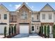 Charming townhome featuring a brick facade, attached garage, and well-maintained landscaping at 2968 Greyhawk Ln, Cumming, GA 30040