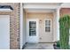 Inviting front porch featuring a white front door, tan siding, and green landscaping at 2968 Greyhawk Ln, Cumming, GA 30040