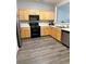 Functional kitchen with stainless steel appliances, light wood cabinetry, and gray wood flooring at 2968 Greyhawk Ln, Cumming, GA 30040
