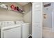 Neat laundry room features washer and dryer with overhead shelving at 2968 Greyhawk Ln, Cumming, GA 30040