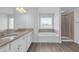 Bright bathroom with granite countertops, double sinks, a soaking tub, and a separate glass shower at 70 Clark Lake Ln, Grayson, GA 30017