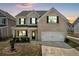 Charming two-story home with light brick facade, inviting front porch, and an attached two-car garage at 70 Clark Lake Ln, Grayson, GA 30017