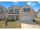 Charming two-story home with a light brick exterior, attached garage, and beautifully manicured landscaping at 70 Clark Lake Ln, Grayson, GA 30017