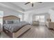 Bright main bedroom featuring wood floors, tray ceiling, sitting area, natural light, and neutral walls at 70 Clark Lake Ln, Grayson, GA 30017