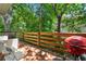 Back deck with a red grill, a white wicker chair and table, and green trees at 1326 Mcpherson Ave., Atlanta, GA 30316