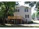 Backyard view of a two-story house with a wooden deck, stairs, and shade trees at 1326 Mcpherson Ave., Atlanta, GA 30316