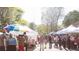 Bustling outdoor market with vendor tents and shoppers browsing various goods at 1326 Mcpherson Ave., Atlanta, GA 30316