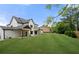 A beautifully landscaped backyard featuring a spacious lawn and pristine white home exterior with modern design elements at 1375 Harris Rd, Lawrenceville, GA 30043
