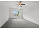 Cozy bedroom with soft carpet, a ceiling fan, and a large window overlooking the neighborhood at 1375 Harris Rd, Lawrenceville, GA 30043