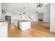 Open-concept kitchen and living space with a large island, modern fixtures, and fireplace at 1375 Harris Rd, Lawrenceville, GA 30043