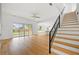 Bright living room featuring wood floors, modern staircase, and sliding glass doors to the backyard at 1375 Harris Rd, Lawrenceville, GA 30043