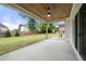 Covered patio with ceiling fan overlooks a lush backyard with wood fence, perfect for outdoor entertaining and relaxation at 1375 Harris Rd, Lawrenceville, GA 30043