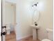 Well-lit bathroom with pedestal sink and wood-look flooring at 1941 Patterson Park Dr, Lawrenceville, GA 30044