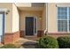 Charming front door entrance with brick accents, covered porch and manicured bushes at 2384 Coach Way, Jonesboro, GA 30236