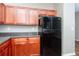 Well-lit kitchen featuring wood cabinetry, black appliances, and dark countertops at 2384 Coach Way, Jonesboro, GA 30236