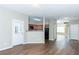 Open living area with wood floors and a view of the kitchen featuring dark appliances at 2384 Coach Way, Jonesboro, GA 30236