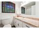Bright bathroom featuring marble-look countertops, white cabinets, and a large window at 2341 Cedar Dr, Lawrenceville, GA 30043