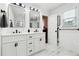 Bathroom with double vanity, sleek mirrors, white cabinets, and marble flooring at 3730 Willow Mill Dr, Lawrenceville, GA 30044