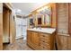 Bathroom with wood paneling, shower, toilet, and a wood vanity with a large mirror at 3730 Willow Mill Dr, Lawrenceville, GA 30044