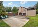Rear exterior of home featuring a basketball court, driveway, and beautifully maintained lawn at 3730 Willow Mill Dr, Lawrenceville, GA 30044