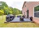 Outdoor back patio featuring a grill, a fire pit, a dining set, and a comfy sofa at 6990 Annie Walk, Lithonia, GA 30038