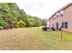 Large backyard featuring a back patio with outdoor seating, a grill, and firepit with a lush lawn at 6990 Annie Walk, Lithonia, GA 30038