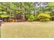 Landscaped backyard with mature trees and decorative plantings at 6990 Annie Walk, Lithonia, GA 30038