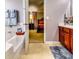 Bright bathroom featuring a tub and cherry wood cabinets, with a peek into the Primary bedroom at 6990 Annie Walk, Lithonia, GA 30038