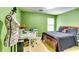 Comfortable bedroom featuring green walls, a queen bed, a full desk setup, and a charming mannequin at 6990 Annie Walk, Lithonia, GA 30038