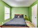 Bedroom with light-green walls featuring a queen-sized bed and a view from the window at 6990 Annie Walk, Lithonia, GA 30038