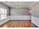 Formal dining room features hardwood flooring, chair rail and wainscoting, and a modern chandelier at 6990 Annie Walk, Lithonia, GA 30038