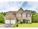 Charming two-story brick home featuring an attached two-car garage, well-manicured lawn and mature landscaping at 6990 Annie Walk, Lithonia, GA 30038